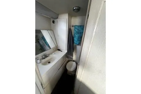 Slide: The Image of 1990 Hatteras 40 Motor Yacht bathroom with sink, mirror, and toilet. - 11