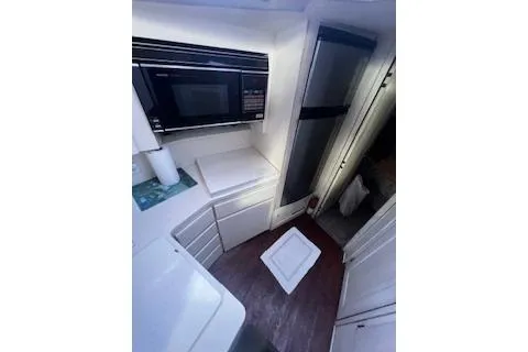 Slide: The Image of 1990 Hatteras 40 Motor Yacht kitchen with microwave and compact design. - 14