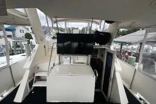 Slide: The Image of 1990 Hatteras 40 Motor Yacht interior with helm, seating, and marina view. - 6