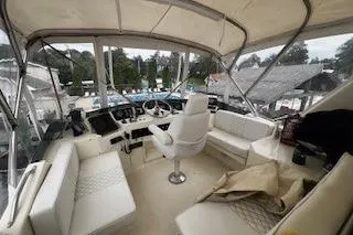 Slide: The Image of 1990 Hatteras 40 Motor Yacht cockpit with white seating and control panel. - 7