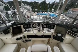 Slide: The Image of Cockpit view of a 1990 Hatteras 40 Motor Yacht with marina backdrop. - 8