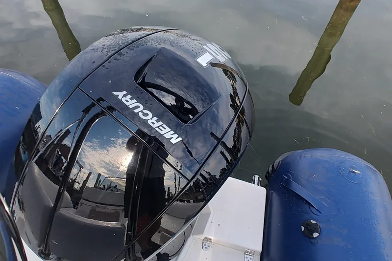 Slide: The Image of 2024 Zodiac N-ZO 680 boat with Mercury engine, reflecting sky and water. - 5