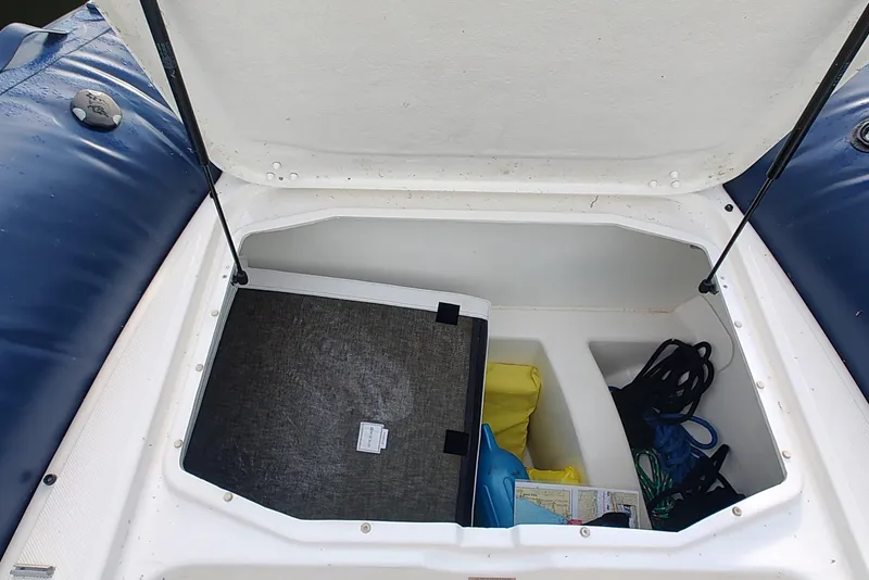 Slide: The Image of Open storage compartment of 2024 Zodiac N-ZO 680 boat with various items inside. - 7