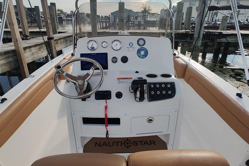 Slide: The Image of 2026 NauticStar 231 Hybrid boat dashboard with steering wheel and control panel at dock. - 11