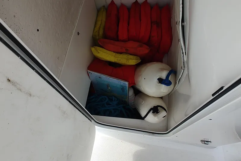 Slide: The Image of Storage compartment in 2026 NauticStar 231 Hybrid boat with life jackets and buoys. - 16