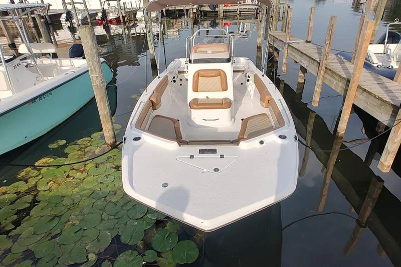 Slide: The Image of 2026 NauticStar 231 Hybrid boat docked, featuring sleek design and comfortable seating. - 2
