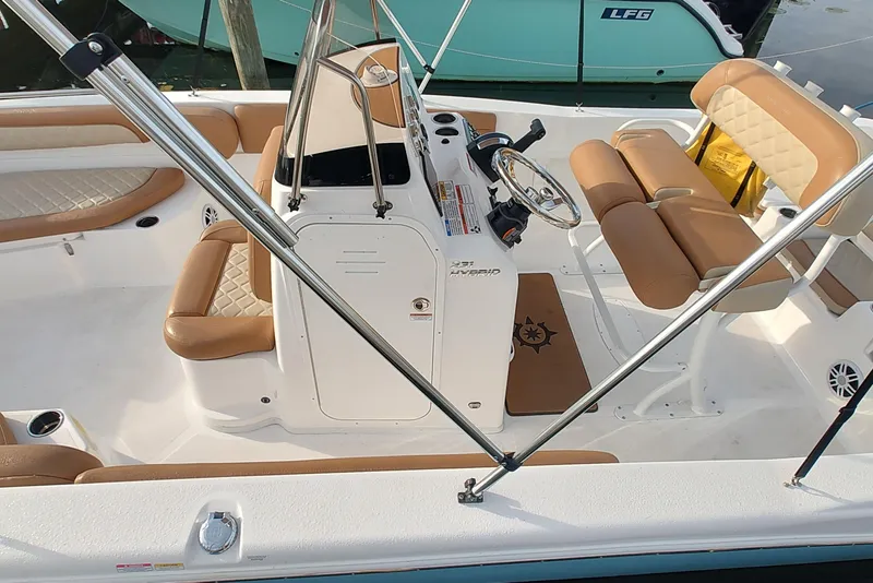 Slide: The Image of 2026 NauticStar 231 Hybrid boat interior with tan seating and steering console. - 5