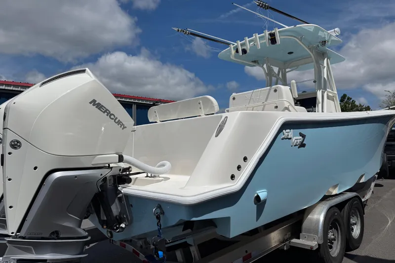 Slide: The Image of 2024 SeaVee 32Z boat with Mercury engine on trailer, under a cloudy sky. - 2