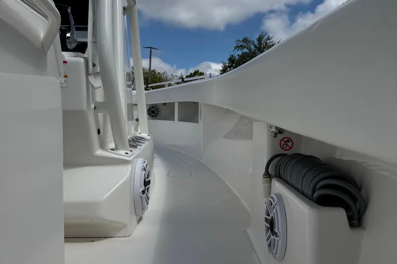 Slide: The Image of 2024 SeaVee 32Z boat deck with speakers and coiled hose, under a partly cloudy sky. - 25