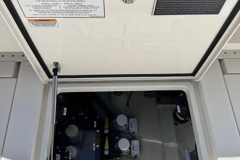Slide: The Image of 2024 SeaVee 32Z boat compartment with visible equipment and warning labels. - 37