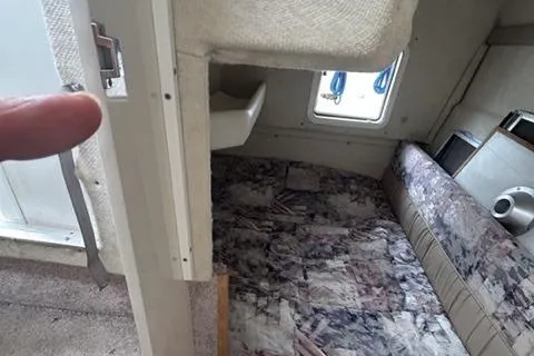 Slide: The Image of 1994 Bayliner 2859 Classic Cruiser cabin interior with seating and window view. - 11