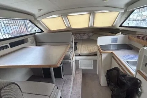 Slide: The Image of 1994 Bayliner 2859 Classic Cruiser interior with dining area, kitchenette, and sleeping space. - 5