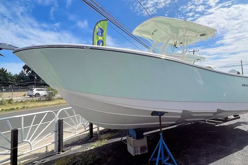 Slide: The Image of 2023 Sea Born SX239 Offshore boat with dual Suzuki engines in a marina setting. - 1