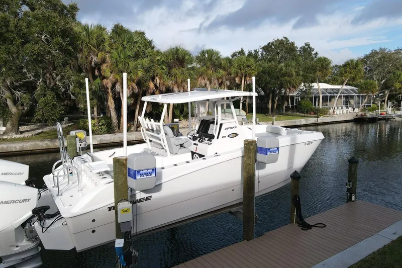 The Image of 2023 Twin Vee 260 GFX boat docked by a scenic canal with lush greenery. - 0