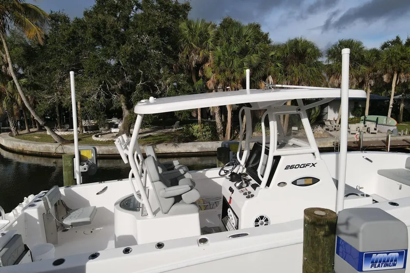 Slide: The Image of 2023 Twin Vee 260 GFX boat docked near lush greenery and calm waters. - 1