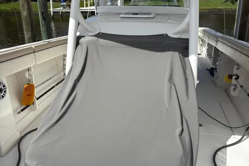 Slide: The Image of 2017 Jupiter 38 FS boat deck with protective cover, docked by the water. - 27
