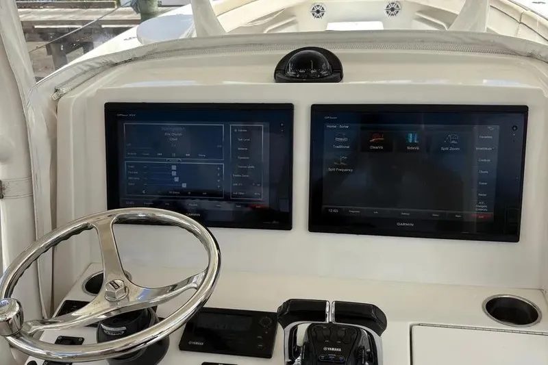 Slide: The Image of 2017 Jupiter 38 FS boat dashboard with dual Garmin displays and steering wheel. - 36