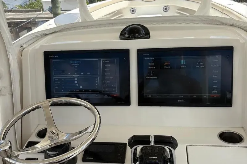 Slide: The Image of 2017 Jupiter 38 FS boat dashboard with dual Garmin displays and steering wheel. - 5