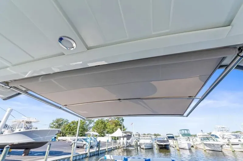 Slide: The Image of 2024 Formula 380 Super Sport Crossover OB boat with extended sunshade at marina. - 18