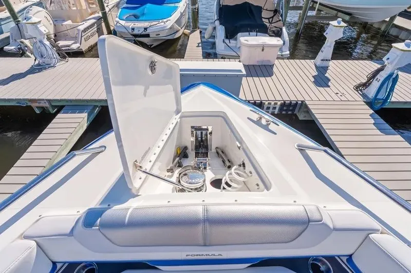 Slide: The Image of 2024 Formula 380 Super Sport Crossover OB boat docked, open storage compartment visible. - 29