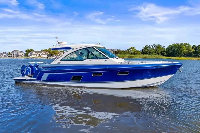 Slide: The Image of 2024 Formula 380 Super Sport Crossover OB cruising on a serene lake. - 4