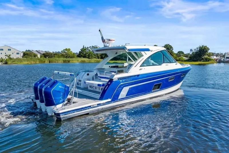 Slide: The Image of 2024 Formula 380 Super Sport Crossover OB boat cruising on a serene lake. - 5