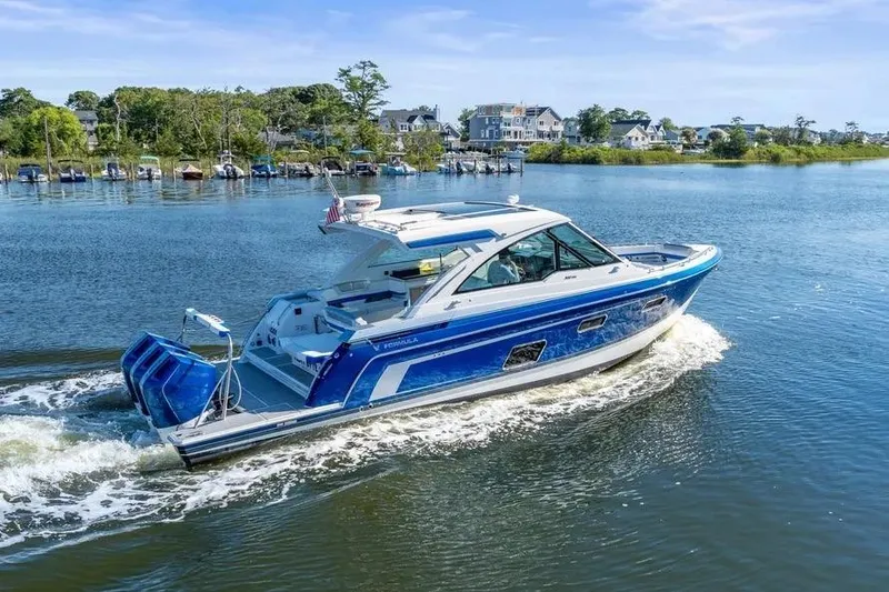 Slide: The Image of 2024 Formula 380 Super Sport Crossover OB cruising on a scenic lake. - 8