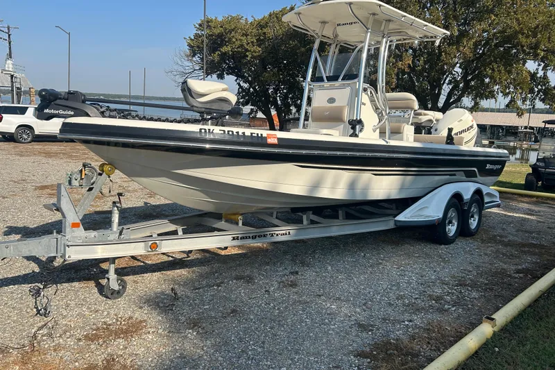 Slide: The Image of 2009 Ranger 2410 Bay Ranger boat on trailer, parked near a lake. - 20