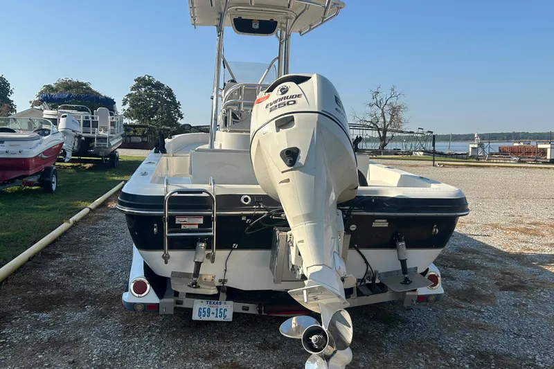 Slide: The Image of 2009 Ranger 2410 Bay Ranger boat with Evinrude 250 engine, parked near a lake. - 3