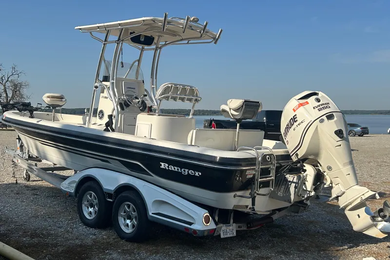 Slide: The Image of 2009 Ranger 2410 Bay Ranger boat with Evinrude engine on trailer by the water. - 4