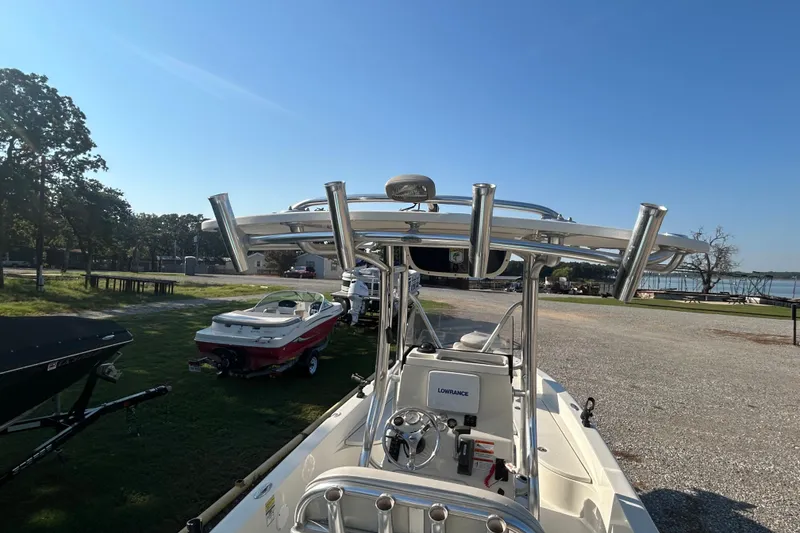 Slide: The Image of 2009 Ranger 2410 Bay Ranger boat with T-top and Lowrance equipment, parked near a lake. - 9