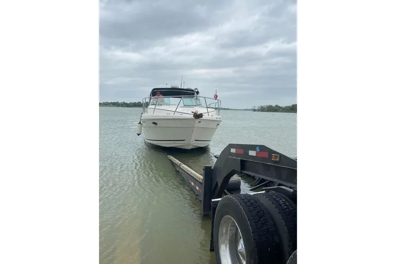 Slide: The Image of 2003 Rinker 342 Express Cruiser being launched into the water on a cloudy day. - 11