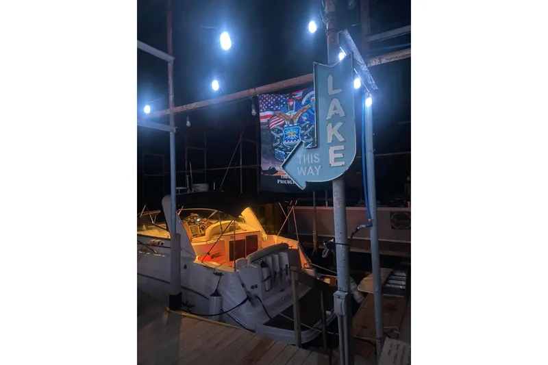 Slide: The Image of 2003 Rinker 342 Express Cruiser docked at night with "Lake This Way" sign. - 17