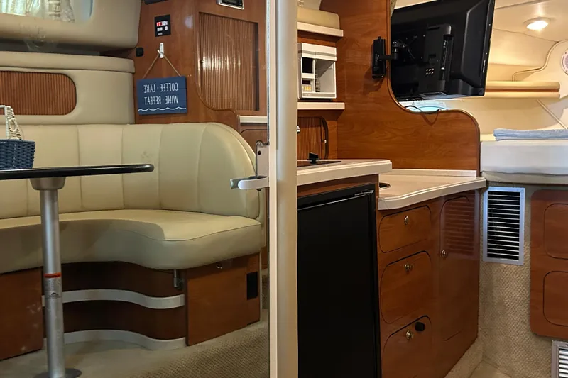 Slide: The Image of Interior of 2003 Rinker 342 Express Cruiser with seating, kitchenette, and TV. - 21