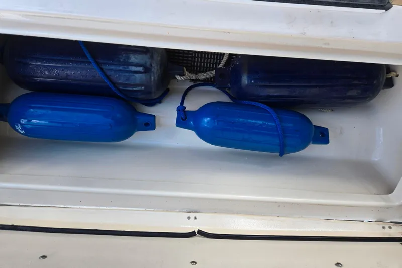 Slide: The Image of Blue boat fenders stored in a compartment of a 2008 Grady-White Gulfstream 232. - 14