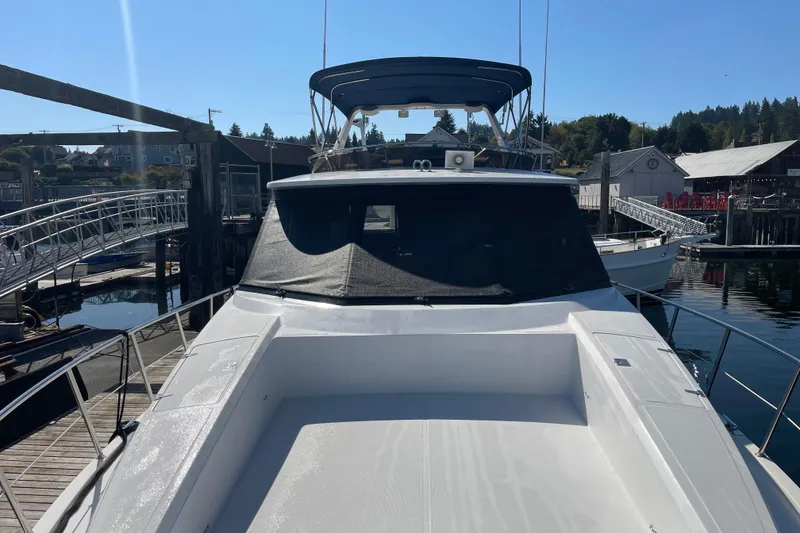 Slide: The Image of 1997 McKinna 48 Pilothouse yacht docked at a marina under clear blue skies. - 20