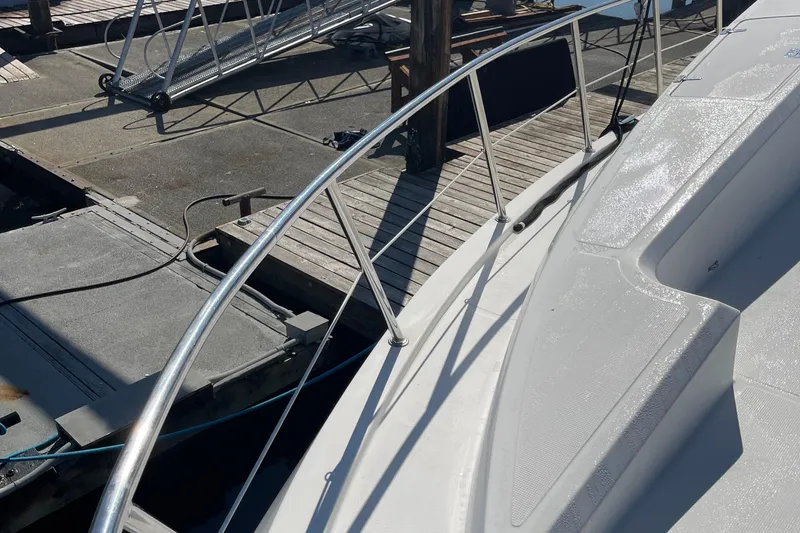 Slide: The Image of 1997 McKinna 48 Pilothouse yacht docked, featuring sleek deck and railing design. - 22