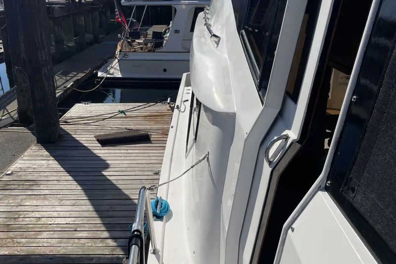 Slide: The Image of 1997 McKinna 48 Pilothouse yacht docked at a wooden pier. - 23