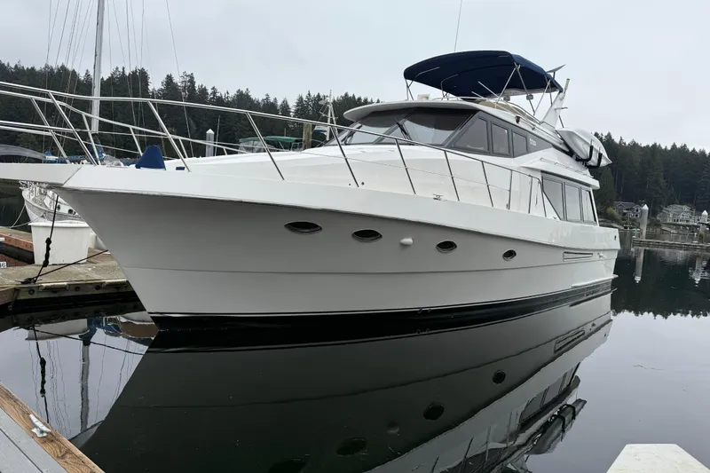Slide: The Image of 1997 McKinna 48 Pilothouse yacht docked in a serene marina setting. - 3