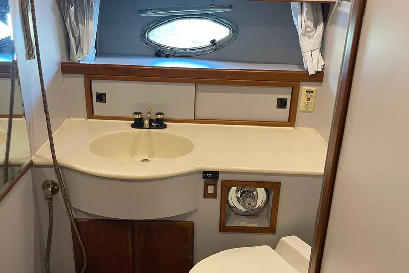 Slide: The Image of Luxurious bathroom in a 1997 McKinna 48 Pilothouse yacht with elegant fixtures and porthole window. - 40