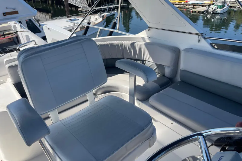 Slide: The Image of 1997 McKinna 48 Pilothouse yacht interior with gray seating and steering wheel. - 43