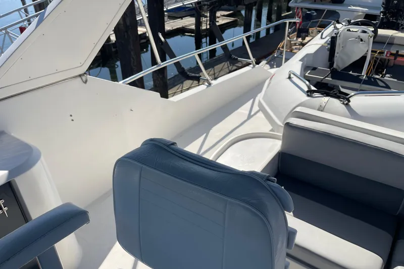 Slide: The Image of 1997 McKinna 48 Pilothouse yacht interior with seating and helm, docked at marina. - 45