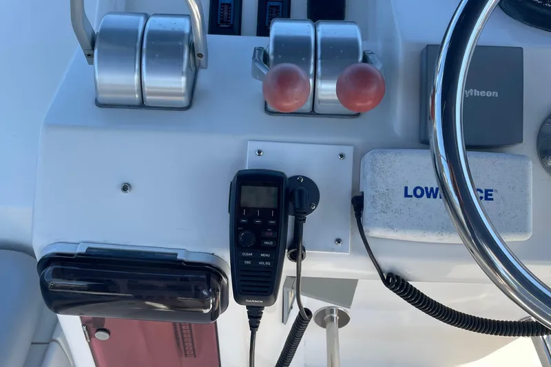 Slide: The Image of Control panel of a 1997 McKinna 48 Pilothouse with steering wheel and navigation equipment. - 49