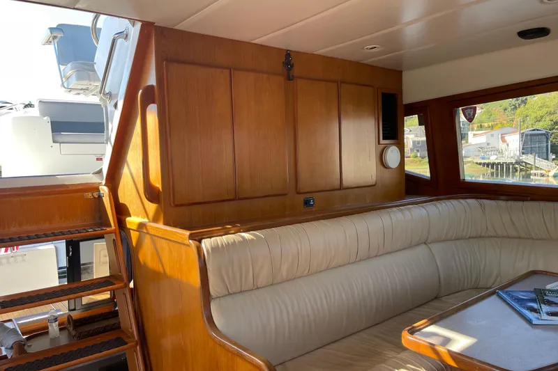Slide: The Image of Interior of 1997 McKinna 48 Pilothouse with wooden paneling and cream seating. - 54