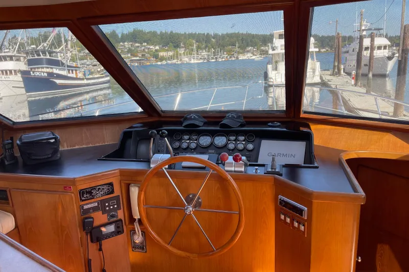 Slide: The Image of 1997 McKinna 48 Pilothouse helm with wooden steering wheel and Garmin navigation system. - 65