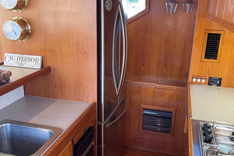 Slide: The Image of Interior of 1997 McKinna 48 Pilothouse yacht kitchen with wood paneling and stainless steel appliances. - 66