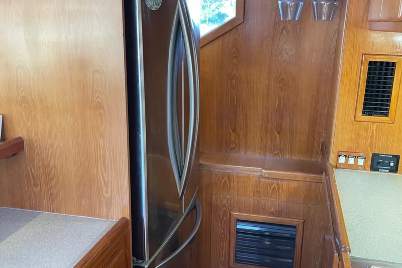 Slide: The Image of Interior of 1997 McKinna 48 Pilothouse with wood paneling and stainless steel refrigerator. - 72