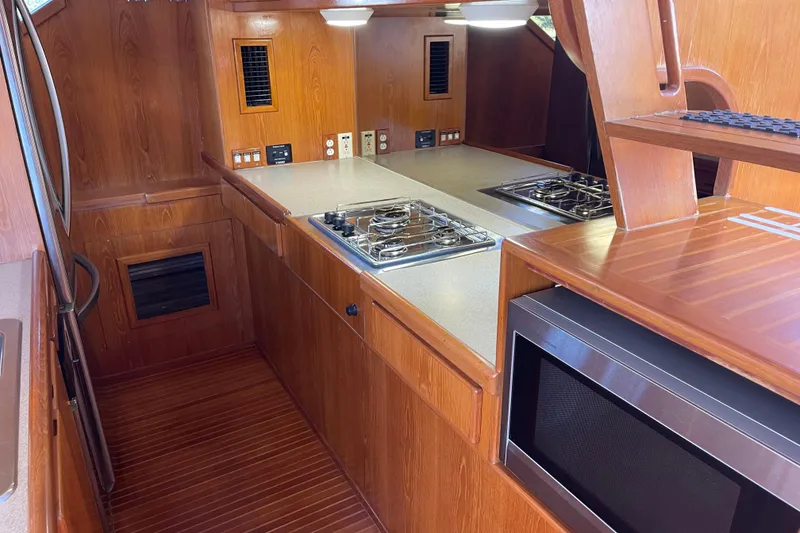 Slide: The Image of 1997 McKinna 48 Pilothouse kitchen with wood cabinetry, stove, and microwave. - 73