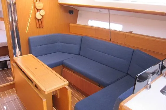 Slide: The Image of 2011 Jeanneau Sun Odyssey 42 DS interior with blue seating and wooden accents. - 2