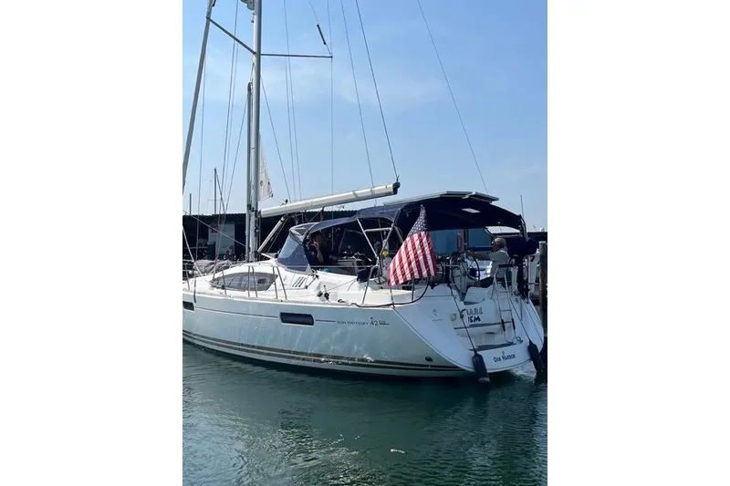 Slide: The Image of 2011 Jeanneau Sun Odyssey 42 DS sailboat docked with American flag displayed. - 4